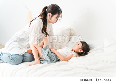 ベッドで娘を寝かしつける母親(子育て,育児) ベッドで娘を寝かしつける母親(子育て,育児) 135078331