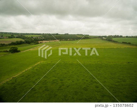 Green landscape against cloudy sky 135078602