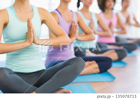 Five women are practicing yoga in bright flat design studio, wearing colorful athletic wear on mats Five women are practicing yoga in bright flat design studio, wearing colorful athletic wear on mats 135078713
