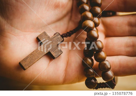 Hand holding rosary beads Hand holding rosary beads 135078776