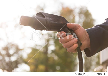 Man holding charging plug 135078801