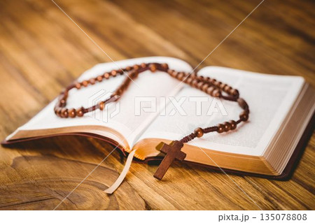 Rosary beads on open bible 135078808