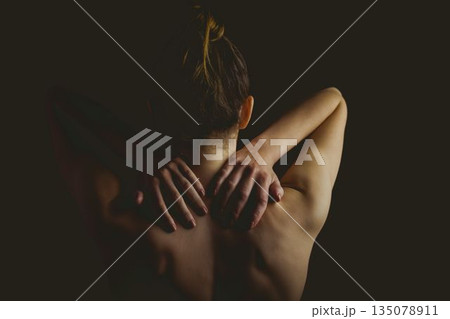 Woman is raising arms under lights highlighting contours on dark backdrop illustration, copy space 135078911