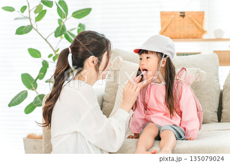 リビングで園児服を着た娘と一緒に歯磨きをする親子,母子,家族,母親 135079024
