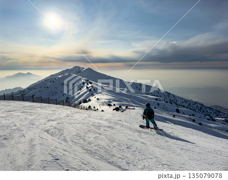Man snowboarding on mountain slope at Amirsoy ski resort. Winter sport activity Man snowboarding on mountain slope at Amirsoy ski resort. Winter sport activity 135079078