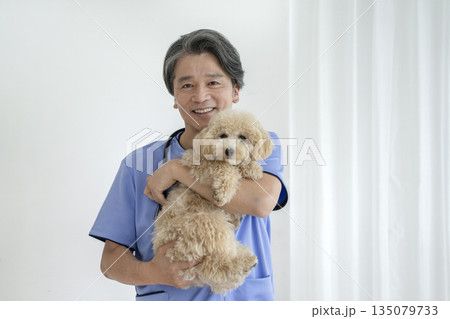 笑顔のベテラン獣医師とビションプーの子犬 135079733