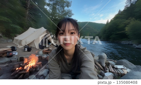 キャンプ場で焚き火をする女性 135080408