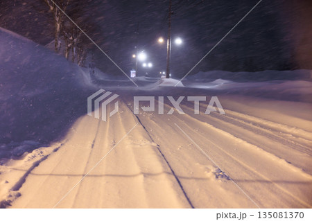 雪道に残るタイヤの跡 深夜の雪道に灯るやさしい街灯 雪道に残るタイヤの跡 深夜の雪道に灯るやさしい街灯 135081370