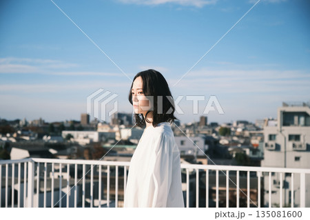 屋上で外を眺める若い女性 屋上で外を眺める若い女性 135081600