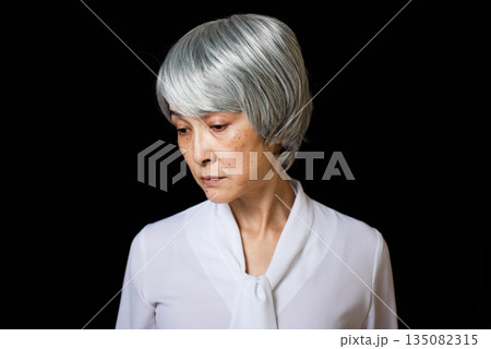 俯いて悲しげな表情のシニア女性 135082315
