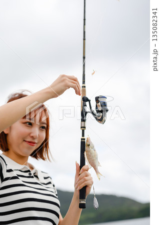 釣り上げた魚を嬉しそうに見る女性 【撮影協力:隠岐シーサイドリゾートみやび様】 釣り上げた魚を嬉しそうに見る女性 【撮影協力:隠岐シーサイドリゾートみやび様】 135082341