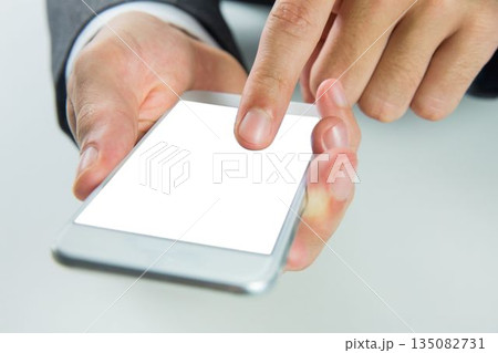 Businessman is tapping blank smartphone in flat design office scene and highlighting groomed hands Businessman is tapping blank smartphone in flat design office scene and highlighting groomed hands 135082731