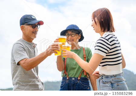 三世代で乾杯、屋外でビール 【撮影協力：隠岐シーサイドリゾートみやび様】 135083296