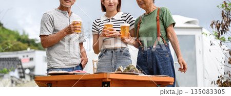 屋外でビールを楽しむ三世代 【撮影協力：隠岐シーサイドリゾートみやび様】 135083305