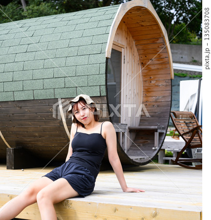 女性が樽型サウナ小屋で休憩 【撮影協力:隠岐シーサイドリゾートみやび様】 女性が樽型サウナ小屋で休憩 【撮影協力:隠岐シーサイドリゾートみやび様】 135083708
