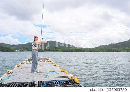 女性が海で魚釣り 【撮影協力:隠岐シーサイドリゾートみやび様】 女性が海で魚釣り 【撮影協力:隠岐シーサイドリゾートみやび様】 135083720