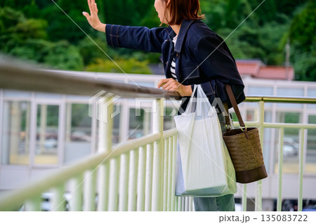 女性が手を振って見送る 135083722