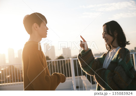 夕暮れ 屋上にいるカップル 135083924