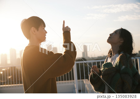 夕暮れ 屋上にいるカップル 135083928