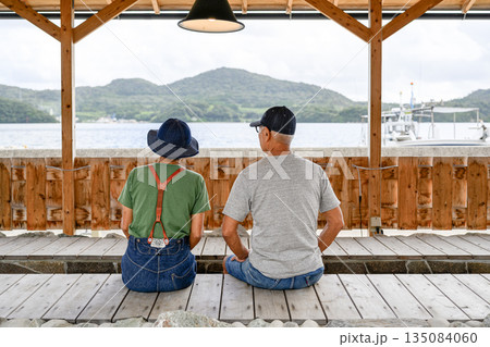 桟橋で海を眺める夫婦 【撮影協力：隠岐シーサイドリゾートみやび様】 135084060