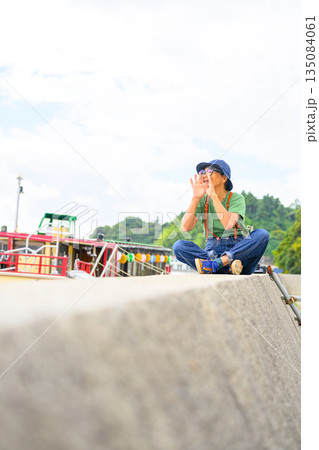 堤防で叫ぶ旅行中の女性 【撮影協力:隠岐シーサイドリゾートみやび様】 堤防で叫ぶ旅行中の女性 【撮影協力:隠岐シーサイドリゾートみやび様】 135084061