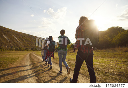 Tourist people walking line rear, outdoor hiking travelling group going countryside trail, footpath Tourist people walking line rear, outdoor hiking travelling group going countryside trail, footpath 135084277