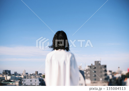 屋上に立つ女性の後ろ姿 135084513