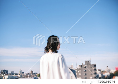 屋上に立つ女性の後ろ姿 135084514