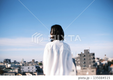 屋上に立つ女性の後ろ姿 135084515
