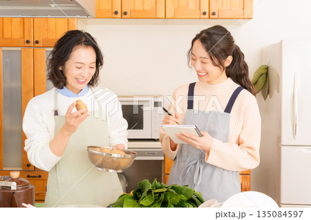 母から料理を教わる娘 母から料理を教わる娘 135084597