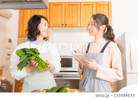 母から料理を教わる娘 母から料理を教わる娘 135084633