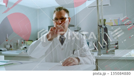 Pointing scientist wearing lab coat raising finger at digital display in lab, showing data overlays 135084880