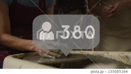 Molding clay vessel with adult man's wet hands at pottery workshop, with user icon showing 380 Molding clay vessel with adult man's wet hands at pottery workshop, with user icon showing 380 135085164
