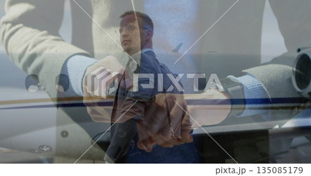 Glancing man wearing business suit, glasses, backpack on jet ramp, with smartwatch and fuselage 135085179