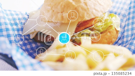 Showing burger sandwich resting on checkered liner in cafe, with cheese, fries and network graphic Showing burger sandwich resting on checkered liner in cafe, with cheese, fries and network graphic 135085234