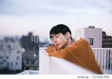 夕暮れ 屋上にいる男性のポートレート 135085309
