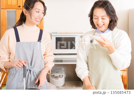 娘の作った肉じゃがの味見をする母 娘の作った肉じゃがの味見をする母 135085473