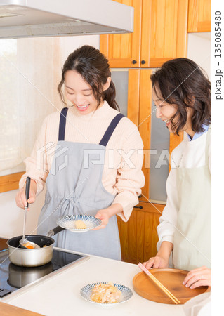 娘の作った肉じゃがの味見をする母 娘の作った肉じゃがの味見をする母 135085480
