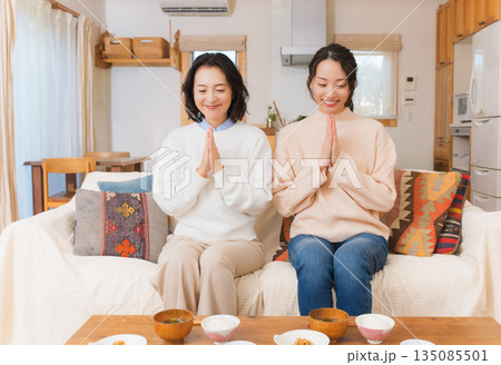 手を合わせて一緒にごはんを食べる母と娘 135085501