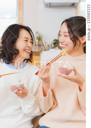 おいしいねと言って笑顔で顔を合わせる母と娘 135085523