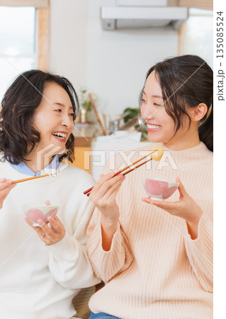 おいしいねと言って笑顔で顔を合わせる母と娘 135085524