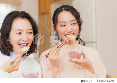 おいしいねと言って笑顔で顔を合わせる母と娘 135085529