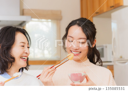 おいしいねと言って笑顔で顔を合わせる母と娘 135085531
