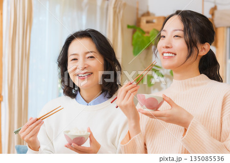 おいしいねと言って笑顔で顔を合わせる母と娘 135085536