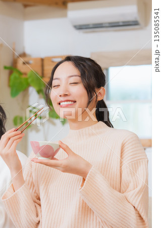 おいしいねと言って笑顔で顔を合わせる母と娘 135085541