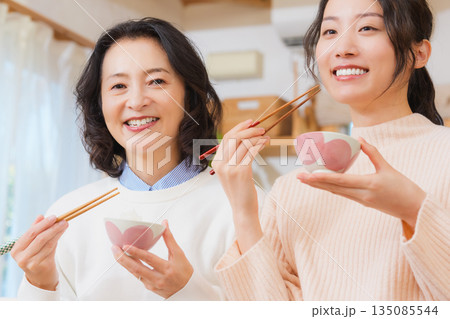 おいしいねと言って笑顔で顔を合わせる母と娘 135085544
