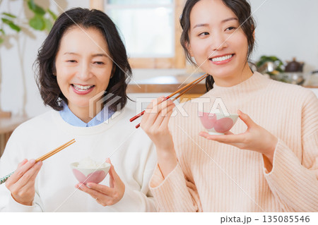 おいしいねと言って笑顔で顔を合わせる母と娘 135085546
