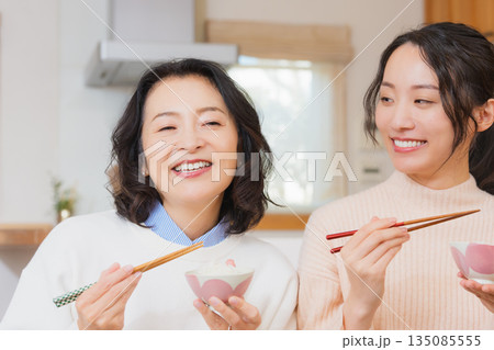 おいしいねと言って笑顔で顔を合わせる母と娘 おいしいねと言って笑顔で顔を合わせる母と娘 135085555