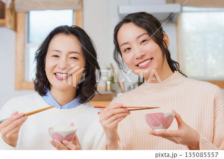 おいしいねと言って笑顔で顔を合わせる母と娘 135085557