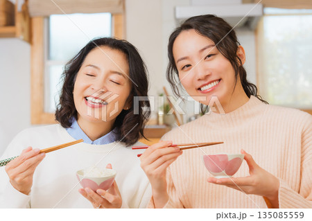 おいしいねと言って笑顔で顔を合わせる母と娘 135085559